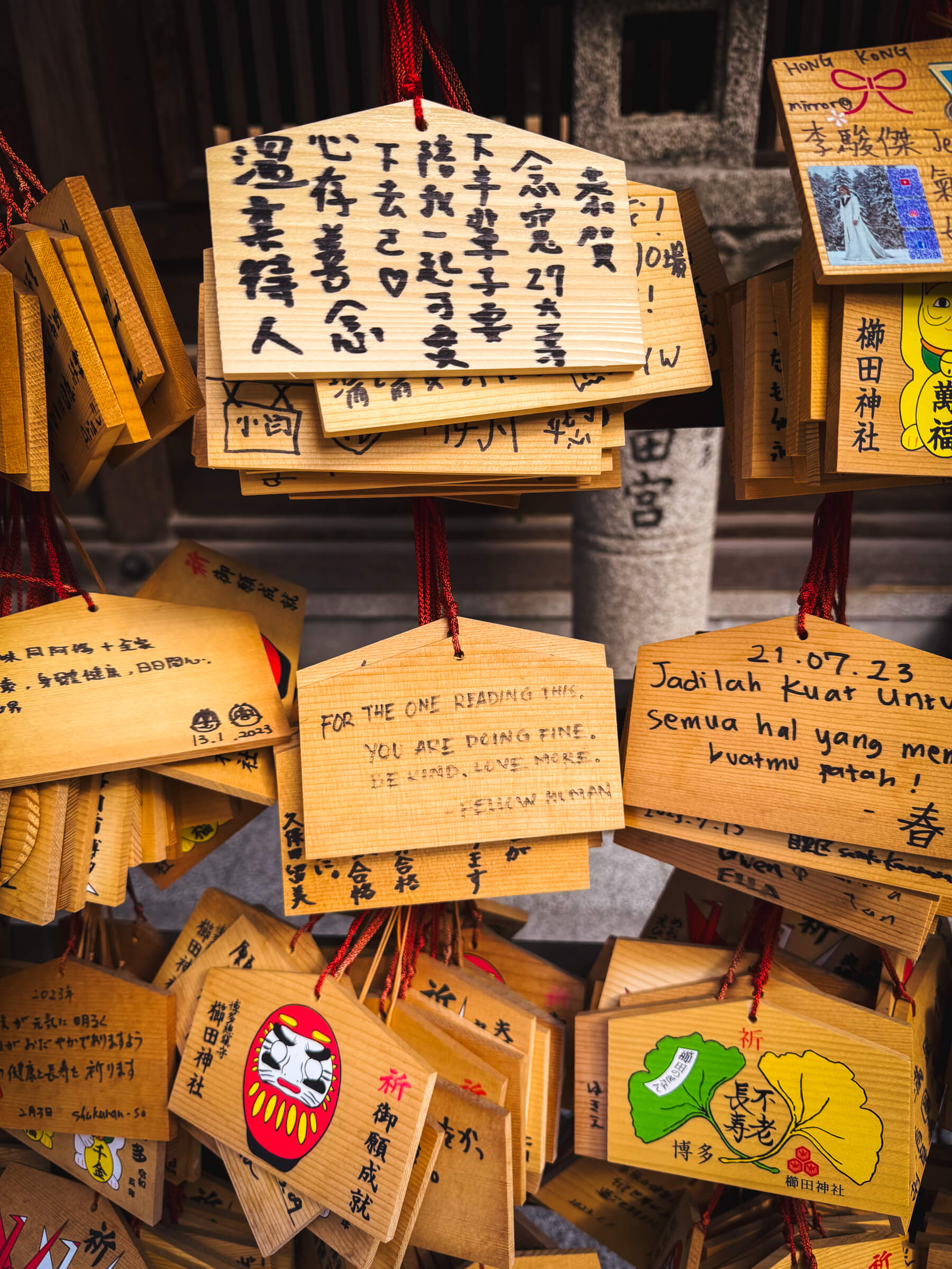 photo of a wooden sign at shrine saying, "for the one reading this, you are doing fine, be kind, love more. – fellow human"