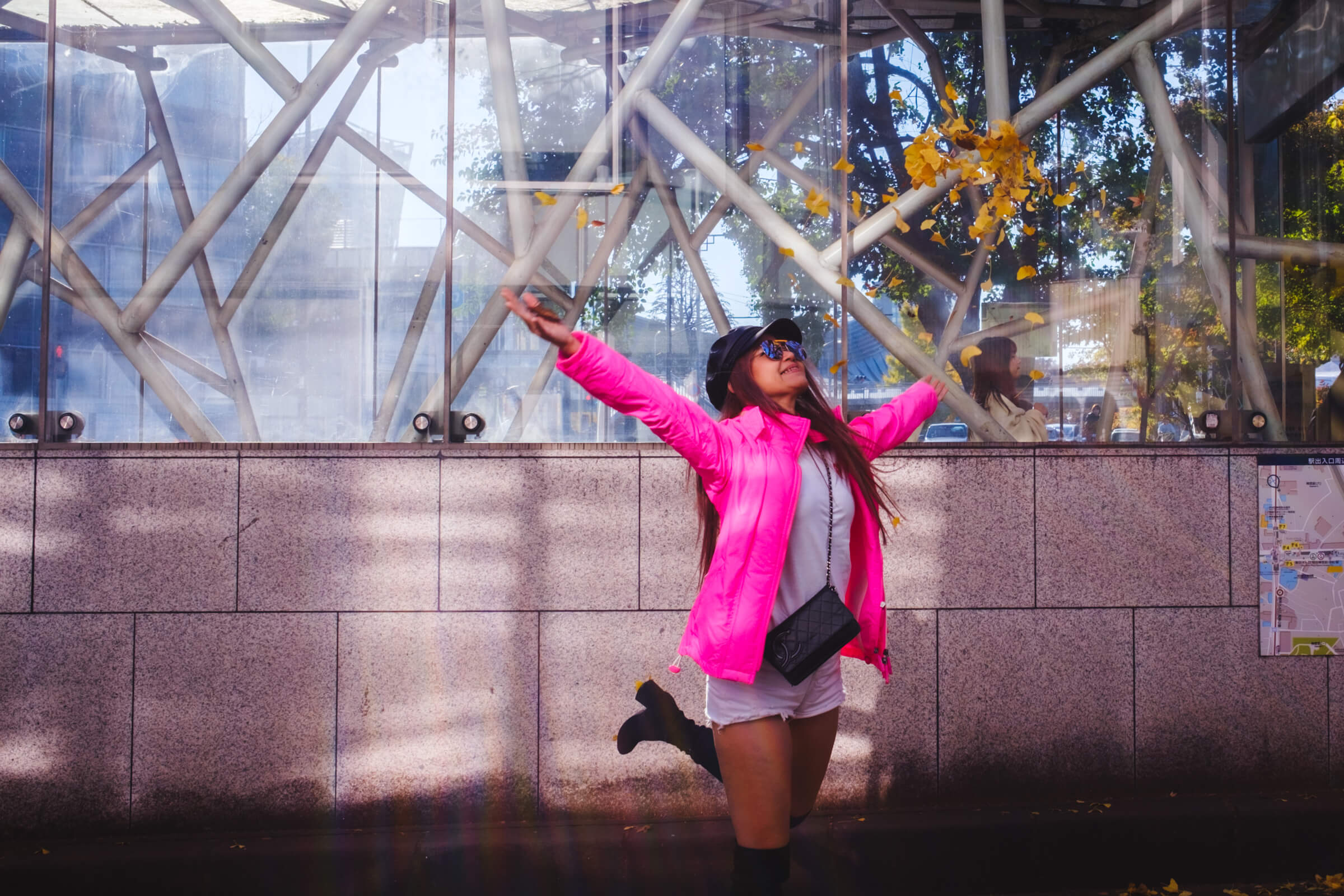 photo of a woman throwing autumn leaves in the air