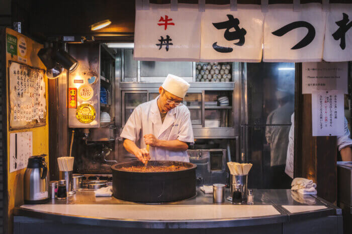 photo of someone stirring a pot of beef offal stew