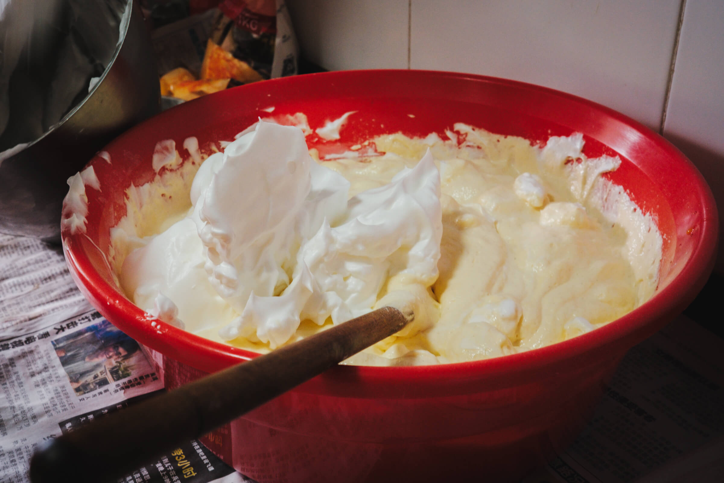 photo of a tub of unmixed mixture containing beaten egg whites, egg yolks, flour and butter: