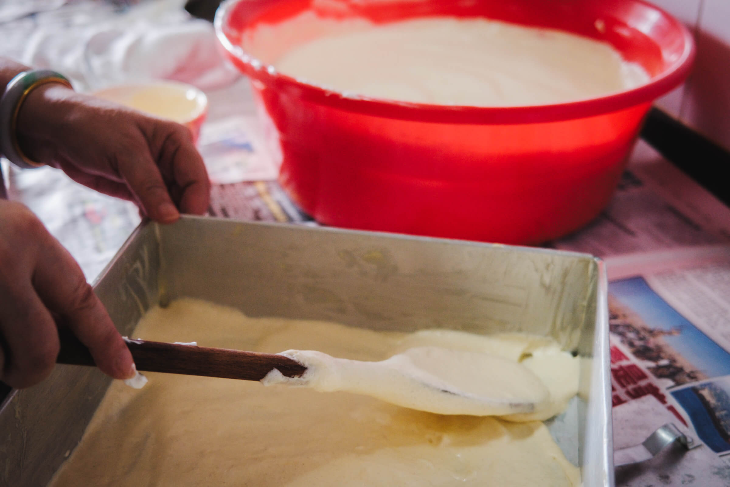 photo of the first layer of cake mixture being spread into the cake pan