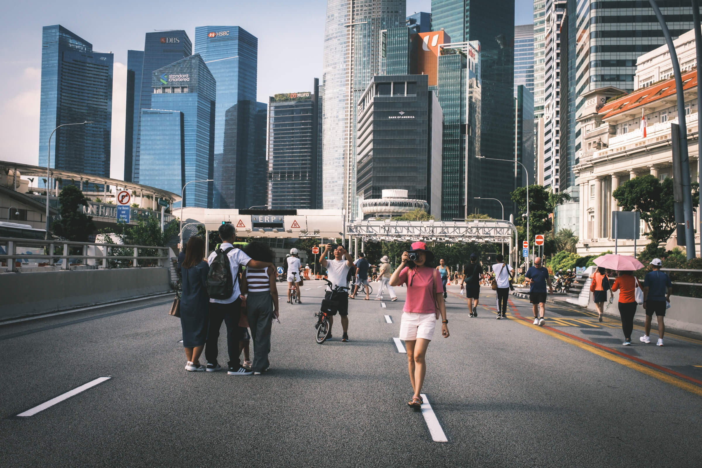 wide shot of my partner holding a camera on a car-free street