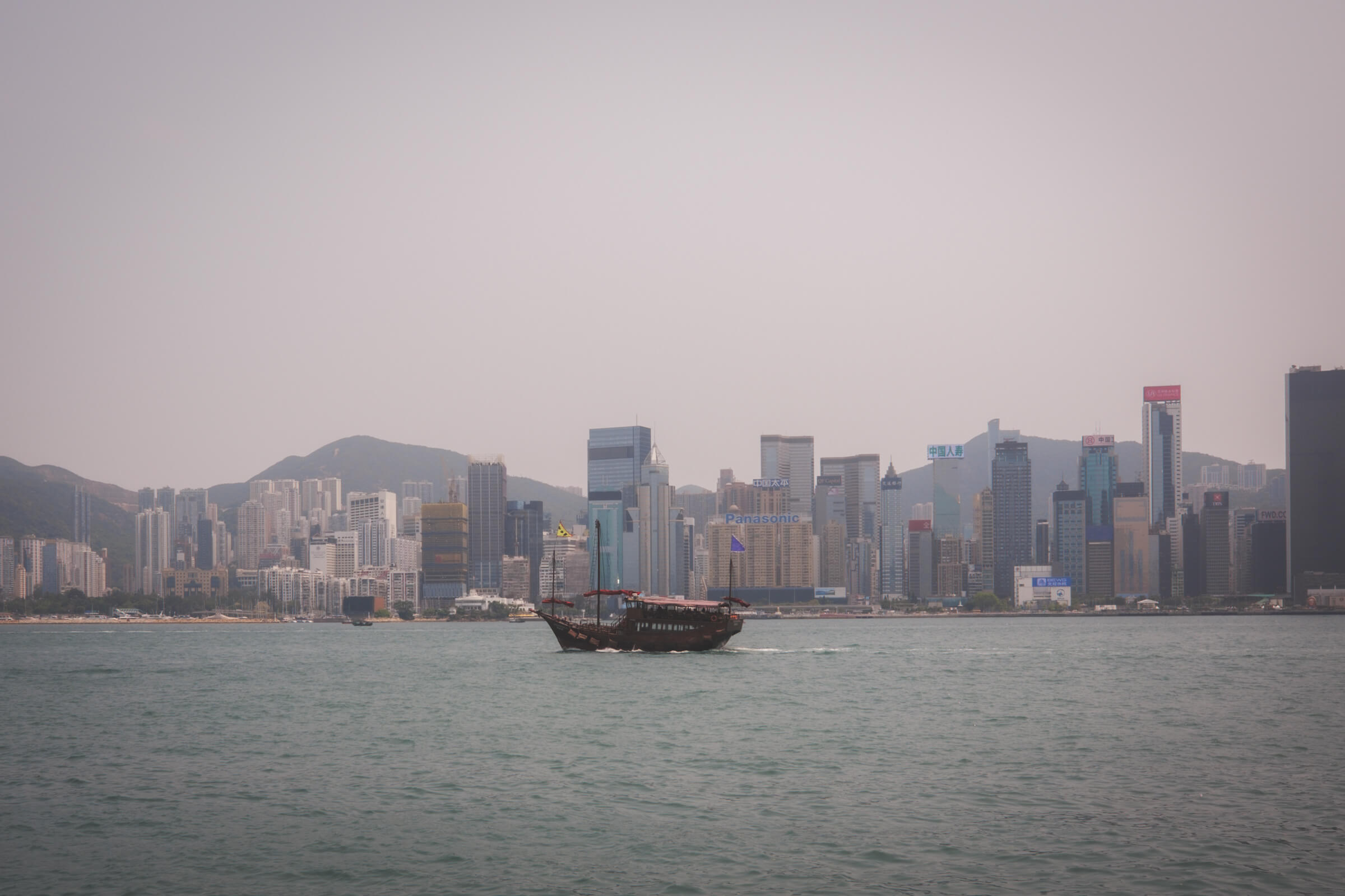 photo of a junk boat against a city backdrop