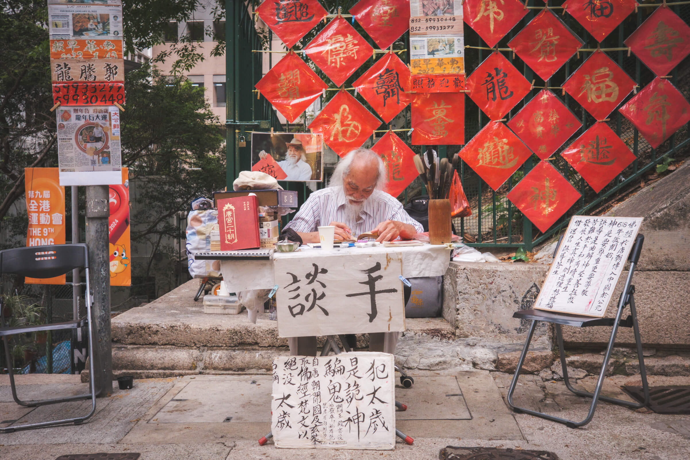 photo of an old man working on chinese calligraphy