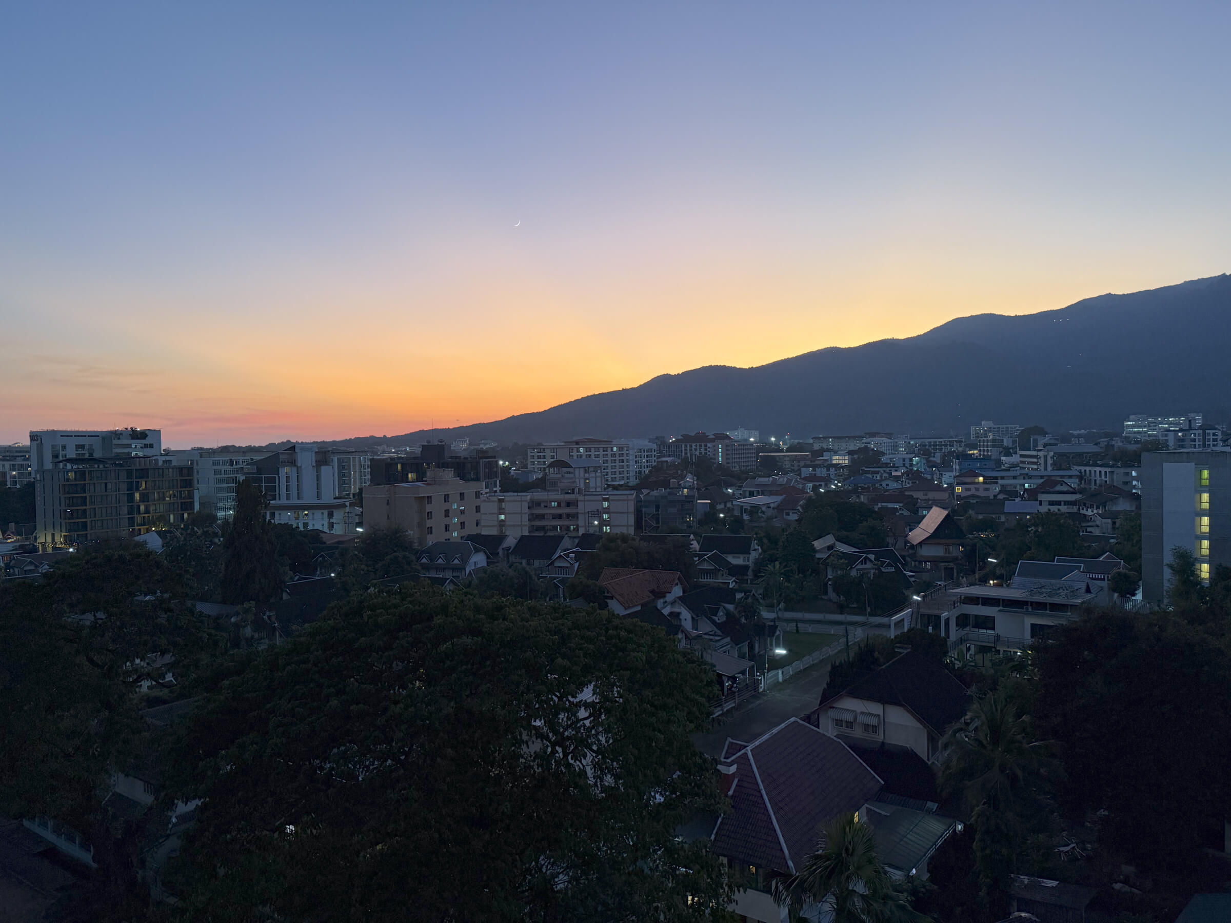 an evening shot of chiangmai's sun setting into the mountains