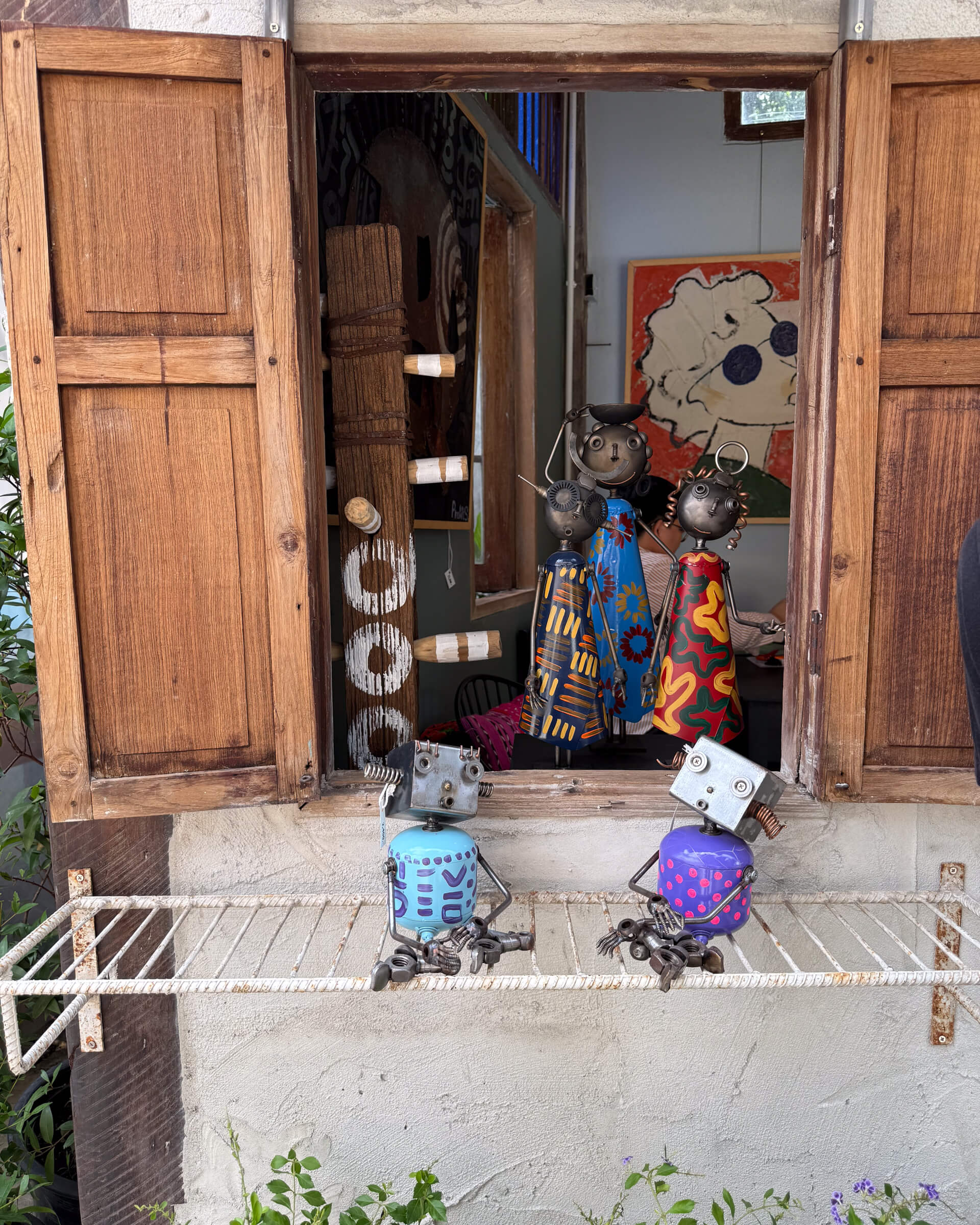 photo of some hand made robots at a window