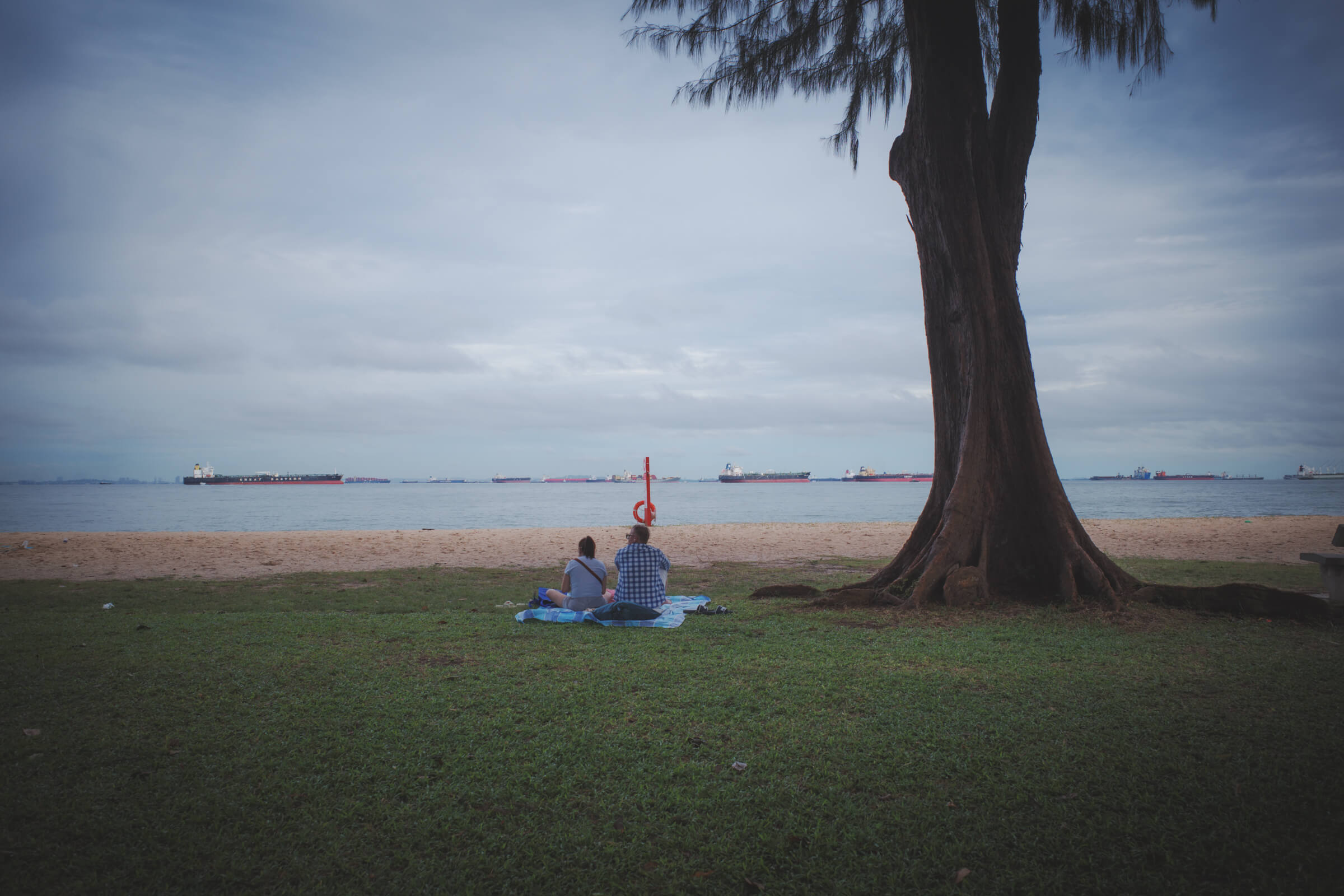 photo of a couple on a picnic mat at the beach
